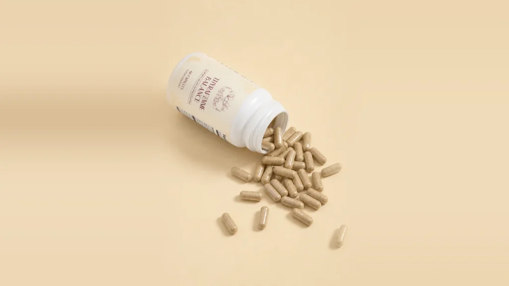 Thyrafemme Balance review: open bottle of Thyrafemme Balance thyroid support capsules for women spilling onto a cream background