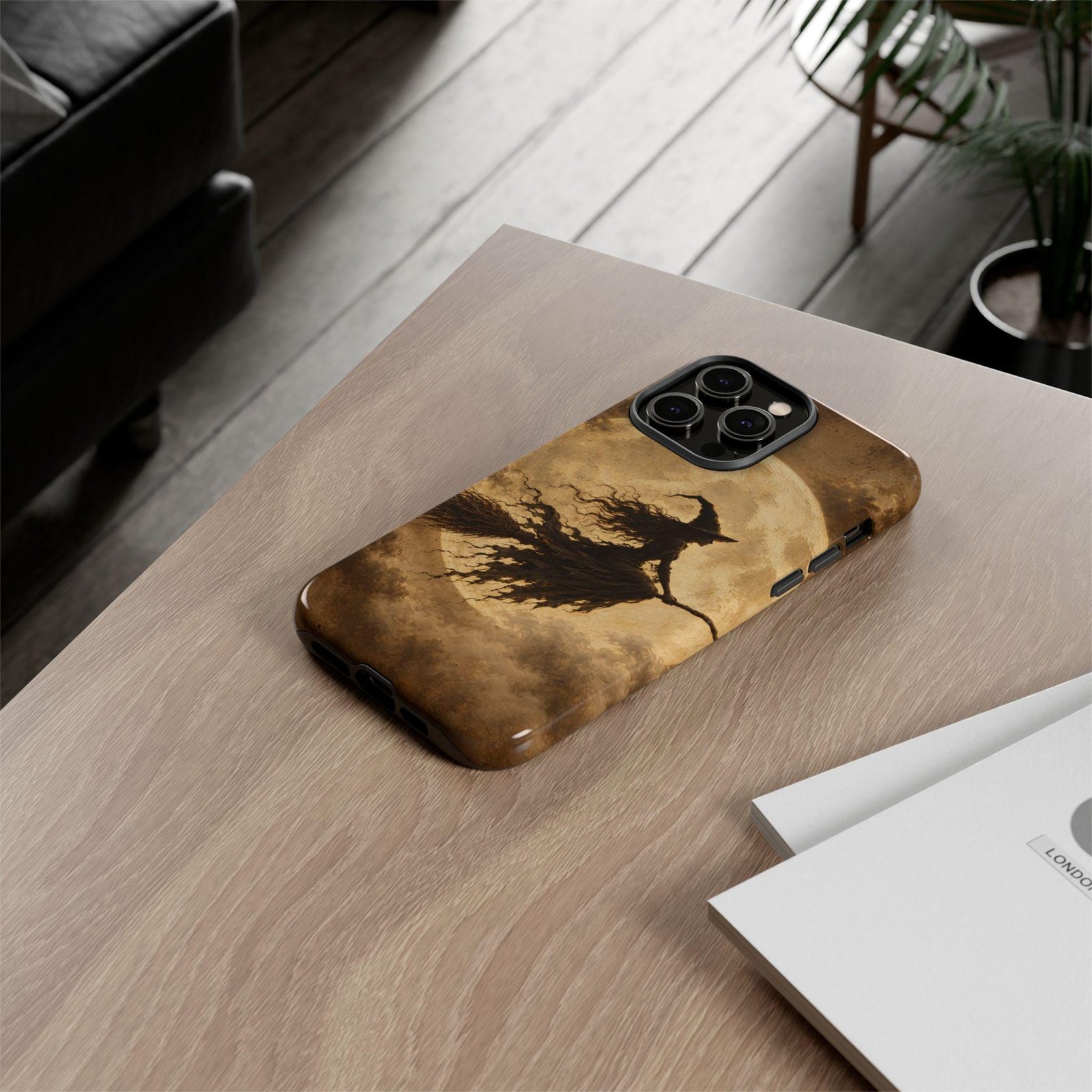 Witch silhouette phone case lying on a wooden table